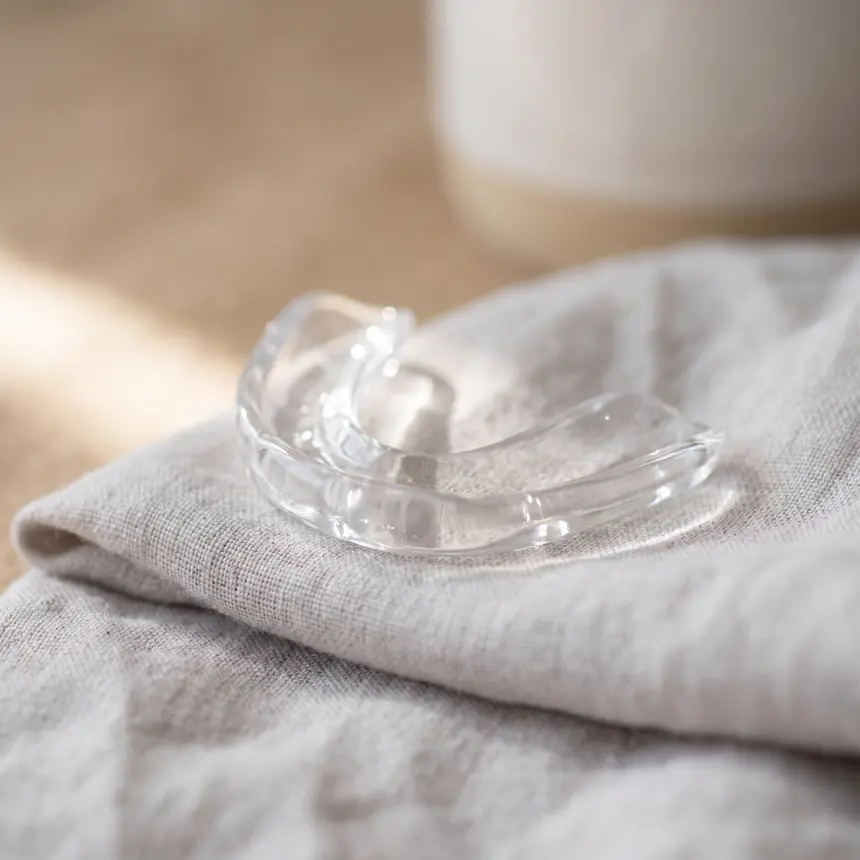 A clear custom-fitted tray resting on folded pale grey linen